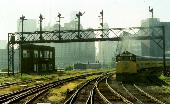 Tower  Clinton Street Tower
The Clinton Street Tower in Chicago was at the junction of the Northwest/North Line and the West Line.  It was just north of the Lake Street Tower.  The train at the right is pushing into the Chicago Passenger Terminal from the West Line.  Photo by Jim H. Yanke, July, 1974
Keywords: Clinton Street Tower Chicago