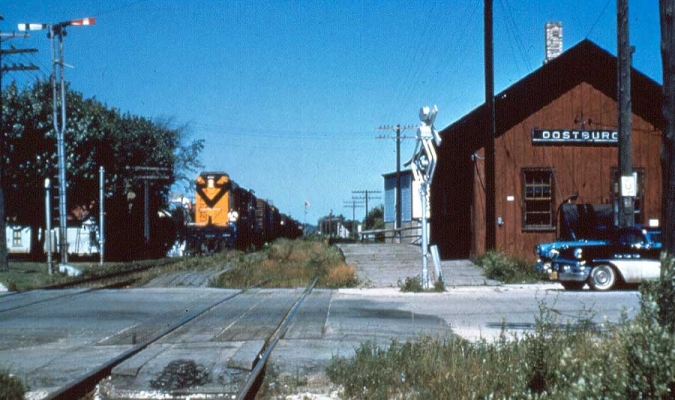 Depot  Oostburg, WI
A southbound freight is approaching the Oostburg, WI depot.  The order board at the left indicates that there are train orders to be picked up.  A wig-wag signal protects the crossing.  Submitted by J. H. Yanke
Keywords: Depot Oostburg