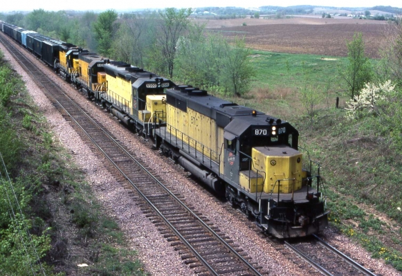 SD40  870  Mt. Vernon, Iowa
A 100 car eastbound grain train is just about to the top of the hill at Mt. Vernon, Iowa on 4-26-85 with a mix of units for power.  SD40 #869, SD45 #6500, GP15 # 4424 and SD40-2 #6903 are in charge today.  Photo by R J Williams
Keywords: SD40 870
