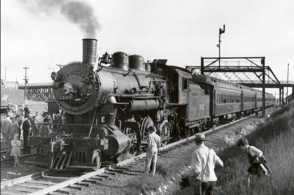 Butler, WI
Class R-1 locomotive 1102 leads a six-car NMRA excursion at Butler, WI.  The train is on the westward main track and the rear coach is under the Hampton Avenue Bridge.  1939 photo, C&NW Historical Society Archives collection.
Keywords: R-1 Butler