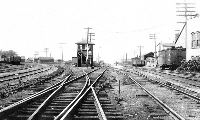 Harvard, IL
Looking west at Tower RD on the west end of Harvard Yard.  The line to Janesville is straight ahead and the line to Chemung and Beloit goes to the left.  Stecher photo, 8-1908.  C&NW Historical Society Archives collection.
Keywords: Harvard, IL