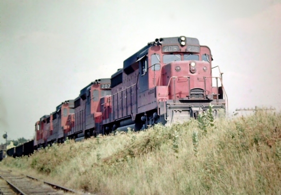 GP30  206  Ingalton, IL
In summer of 1964, a quartet of nearly new CGW GP 30's is ready to leave the small yard at Ingalton, IL, west of Chicago. A stop for nearly every westbound to pick up and set out transfer with the EJ&E. Photo by Tom Zorko

